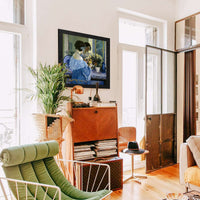 Girl In Blue Arranging Flowers by Frederick Carl Frieseke